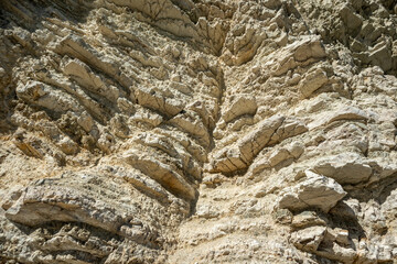 White layered rocks texture, geology close-up, cliff on coast of Lefkada island in Greece. Summer wild nature material surface close-up