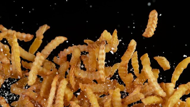 Super Slow Motion Shot of Flying Fresh French Fries with Salt. Filmed on High Speed Cinematic Camera at 1000 fps.