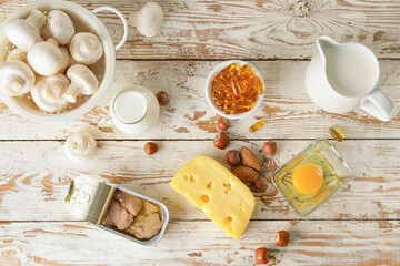 Different healthy products with vitamin D on light wooden background