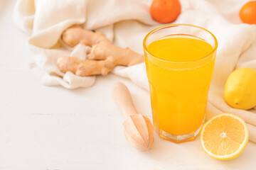 Glass with tasty citrus juice on light wooden background