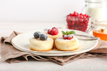 Plate with tasty cottage cheese pancakes and berries on table