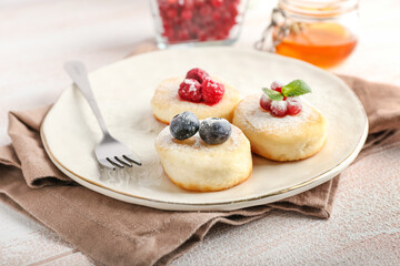 Plate with tasty cottage cheese pancakes and berries on table