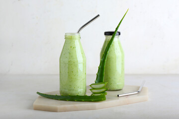 Bottles of healthy aloe juice on white background