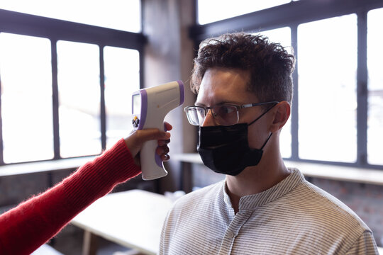 Caucasian man wearing a face mask getting his temperature measured at gin distillery - Powered by Adobe