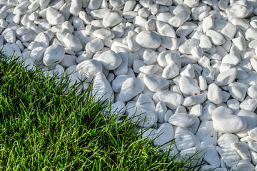 Green grass and white pebble stones background. Toned image