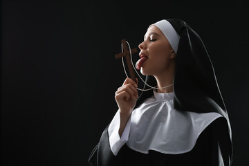 Slutty nun with cross on dark background - obrazy, fototapety, plakaty