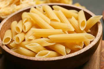 Uncooked penne pasta in bowl