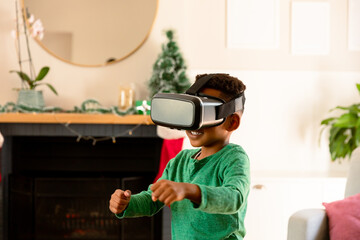 African american boy wearing vr headset and having fun at christmas time