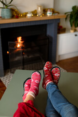 Feet of caucasian couple wearing christmas socks at christmas time