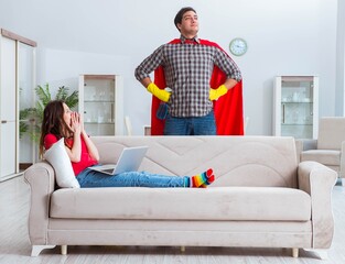 Obraz premium Superhero husband helping his wife at home