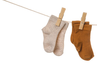 Baby socks hanging on rope against white background