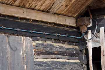 Outdoor metal switchboard for the supply cable near the wooden house.