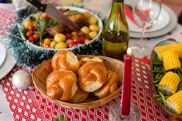 Fresh rolls, dishes, candles and decorations on christmas table