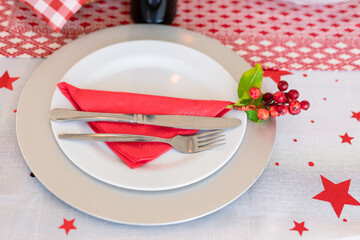 Plates with cutlery, holy and decorations on christmas table