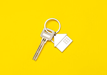 Key with house shape keychain on color background