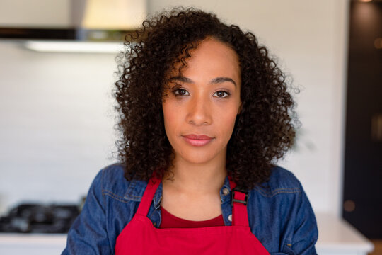 Portrait of serious african american woman wearing apron in kitchen