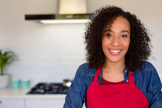 Portrait of happy african american woman wearing apron in kitchen