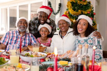 Happy multi generation family wearing santa hats, taking photo