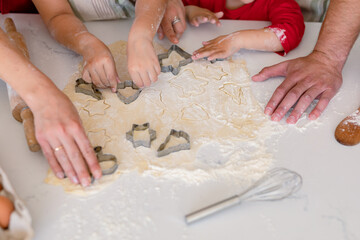 Hands of caucasian family baking together, making cookies in kitchen