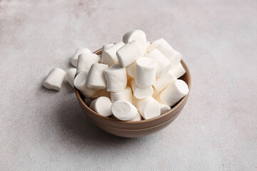 Fototapeta na wymiar Bowl with tasty marshmallows on light background