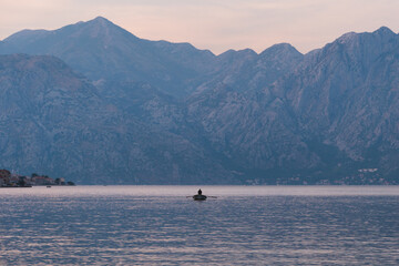 Kotor / Montenegro - September 15 2021: View of a boat and the Kotor Bay at sunset, touristic famous destination in Montenegro, Europe