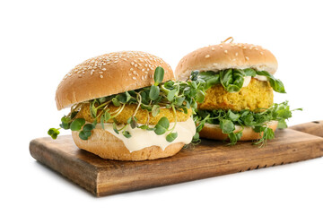 Wooden board with tasty vegetarian burgers on white background