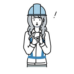 立ってスマートフォンを操作して何かに気づいて驚いた工事現場の女性