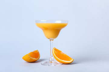 Glass of orange gin and tonic on color background