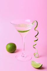 Glass of gin and tonic on color background