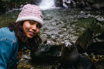 person in a pond with baby seal