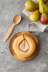 Plate with tasty pear pot pie and fresh fruits on grunge background