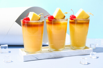 Marble tray with glasses of mai tai cocktail garnished with cherry and pineapple slices
