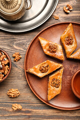 Plate with tasty baklava on wooden background, closeup