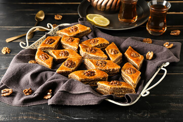 Tray with tasty baklava on dark wooden background