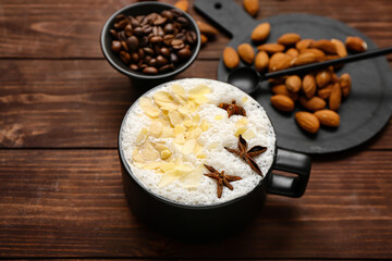Cup of tasty almond latte on wooden background