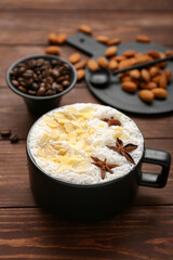 Cup of tasty almond latte on wooden background