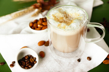 Glass cup of tasty almond latte on table