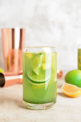 Glass with tasty lemonade on light background