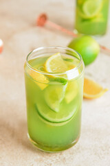 Glass with tasty lemonade on light background
