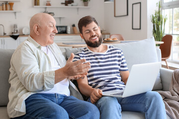 Man and his father with laptop video chatting at home