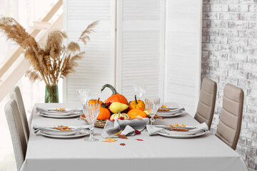 Stylish served table with autumn decor in room