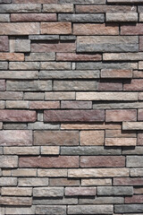 Fototapeta premium Full frame close-up view of a building wall with natural stone in various colors