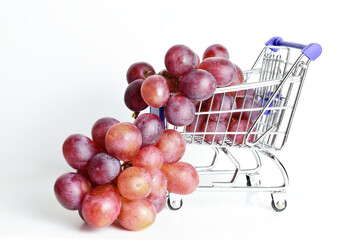 Bunch of grapes in shopping cart and white background.