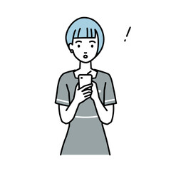 立ってスマートフォンを操作して何かに気づいて驚いたエステ店員の女性