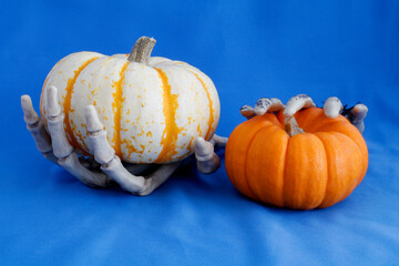 Pumpkins in skeletal hands