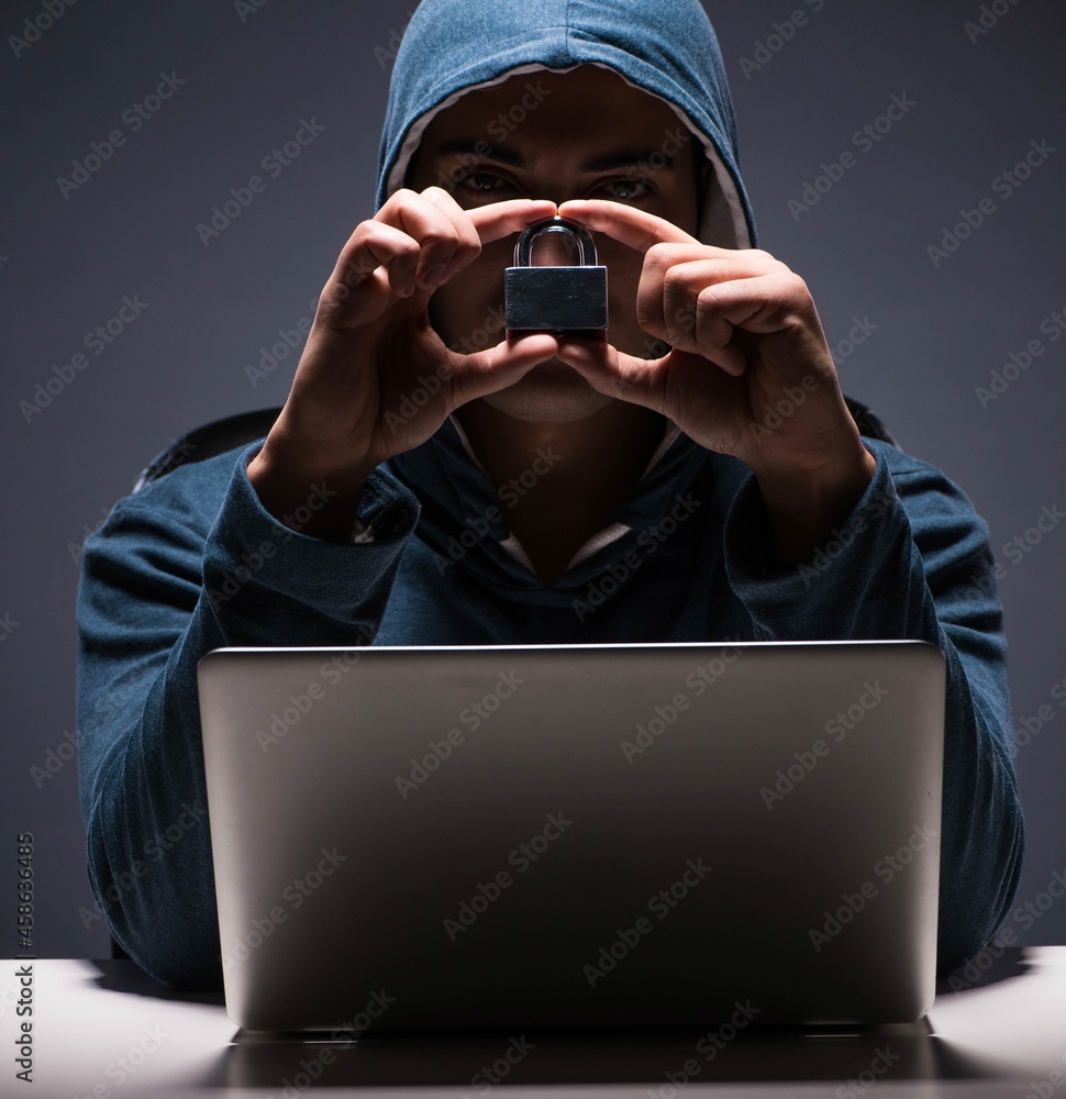Poster computer hacker working in dark room