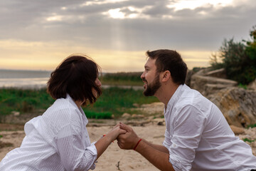 young couple in love look each other in the eye holding hands