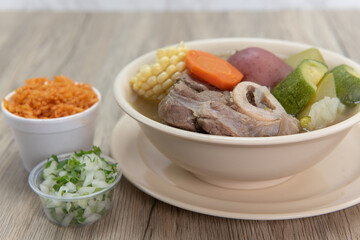 Hearty bowl of Caldo de res Mexican beef stew hot from the stove and served with rice and pico de gallo