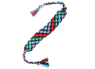 Obraz premium Woven DIY friendship bracelet handmade of embroidery bright thread with knots isolated on white background. 