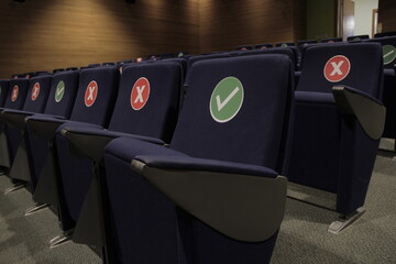 Asientos marcados en sala de cine, marca de sentarse para distanciamiento social. concepto de...